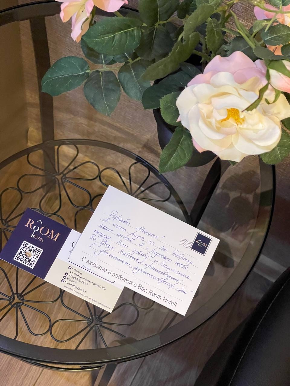Цветы и карточка Room Hotel на столике